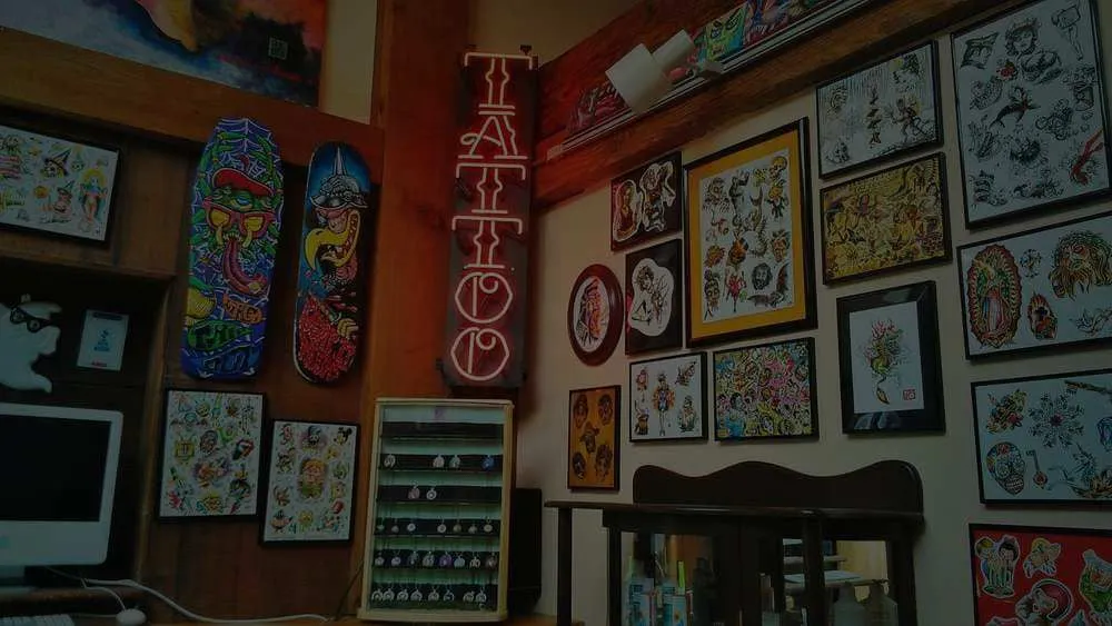 Mission Ink Tattoo shop interior with neon sign and flash art walls